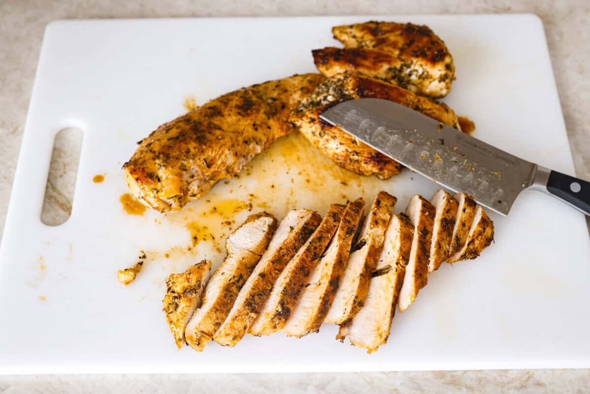 Marry Me Chicken Ramen is the ultimate comfort food mashup you didn’t know you needed! Searing the chicken first locks in moisture and flavor, then it simmers with fresh basil and tangy sun-dried tomatoes in a rich, velvety broth. Overhead shot of cooked chicken sliced on a cutting board.