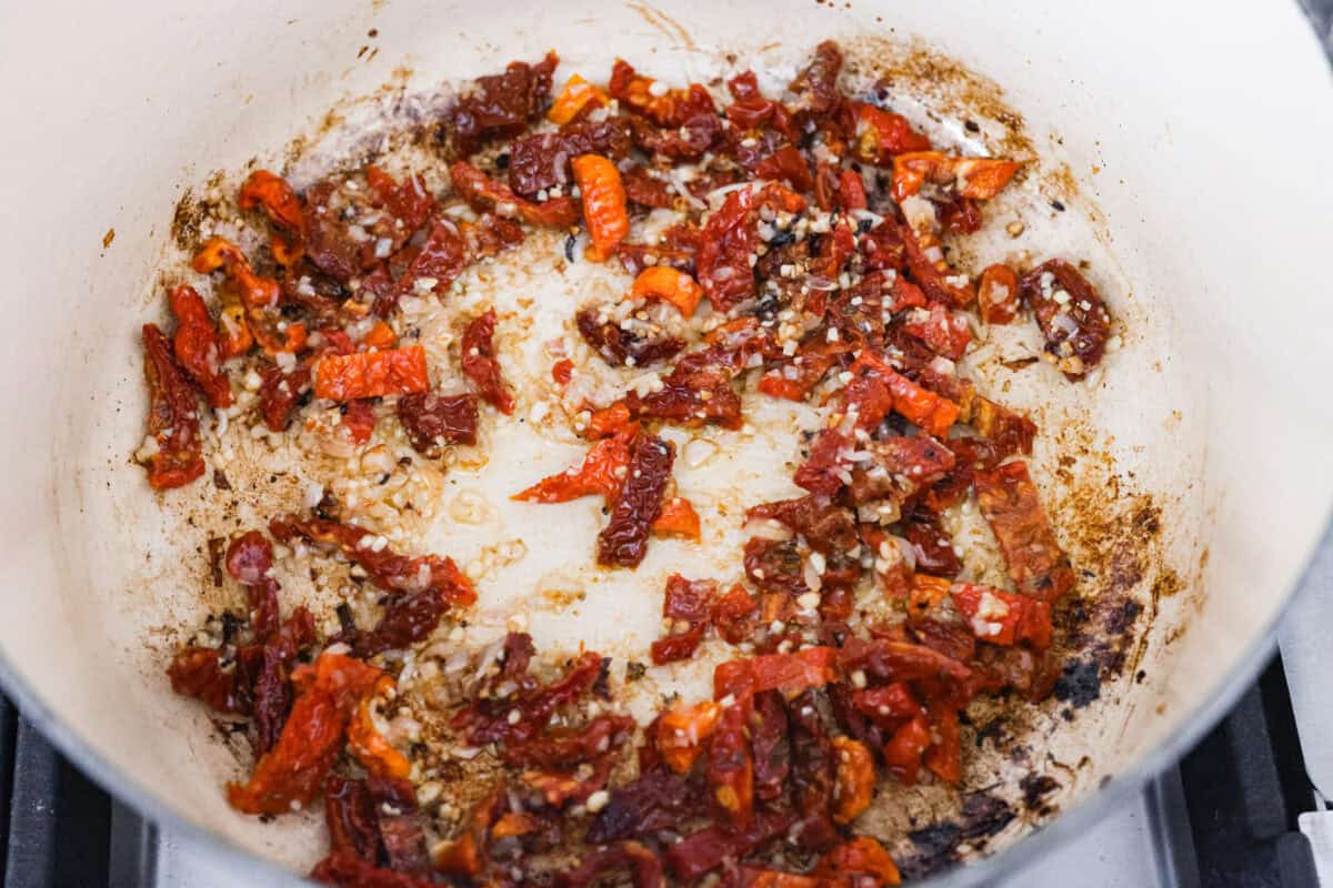 Marry Me Chicken Ramen is the ultimate comfort food mashup you didn’t know you needed! Searing the chicken first locks in moisture and flavor, then it simmers with fresh basil and tangy sun-dried tomatoes in a rich, velvety broth. Sun-dried tomatoes cooking in the shallots and garlic.