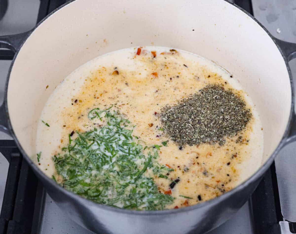 Marry Me Chicken Ramen is the ultimate comfort food mashup you didn’t know you needed! Searing the chicken first locks in moisture and flavor, then it simmers with fresh basil and tangy sun-dried tomatoes in a rich, velvety broth. Angle shot of the cream, broth, basil and seasonings added to the pot to make the marry me ramen broth.