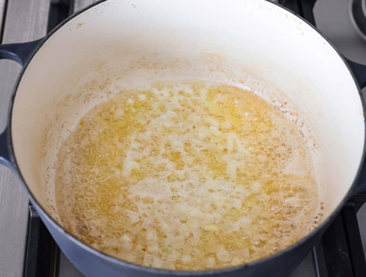 Angle shot of onions sautéing in butter. 