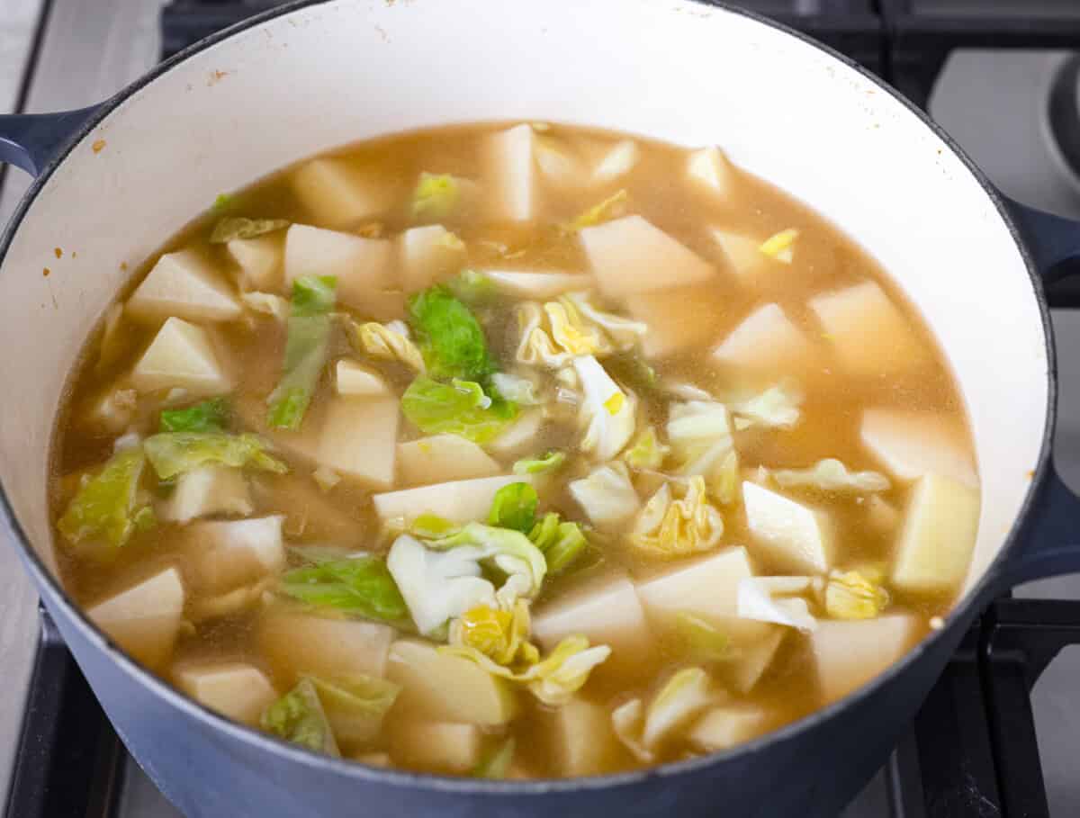 Overhead shot of potatoes, and broth added to the pot. 