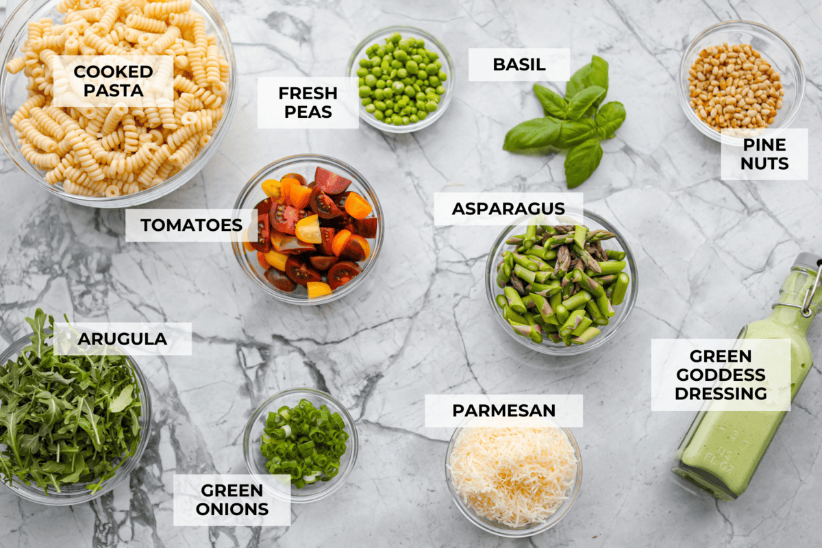 This Green Goddess Pasta Salad is fresh, vibrant, and full of flavor! The creamy herb dressing adds a tangy twist, while crisp spring veggies make it light yet hearty. Perfect for potlucks or any time you’re craving a delicious side! Overhead shot of labeled ingredients.