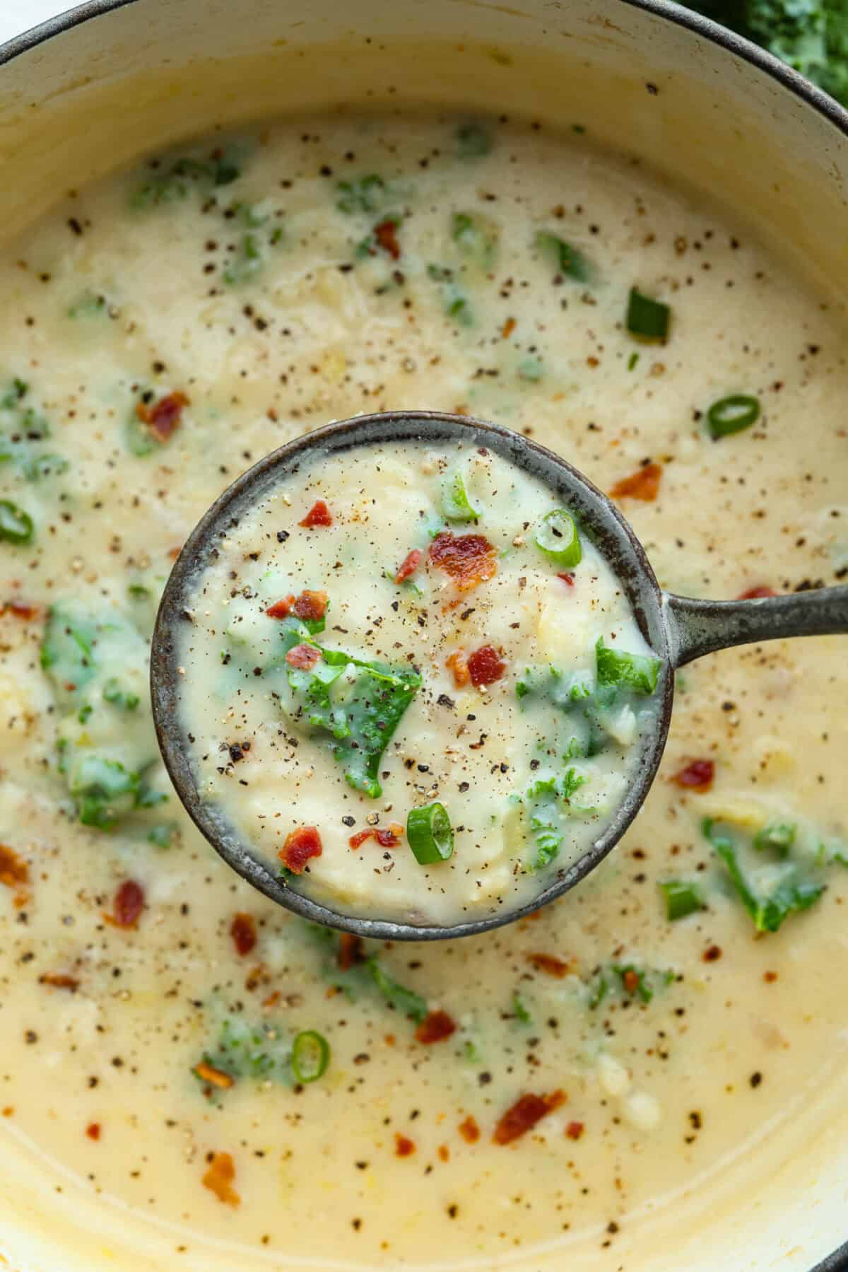 Close up shot of a ladle filled with colcannon soup. 