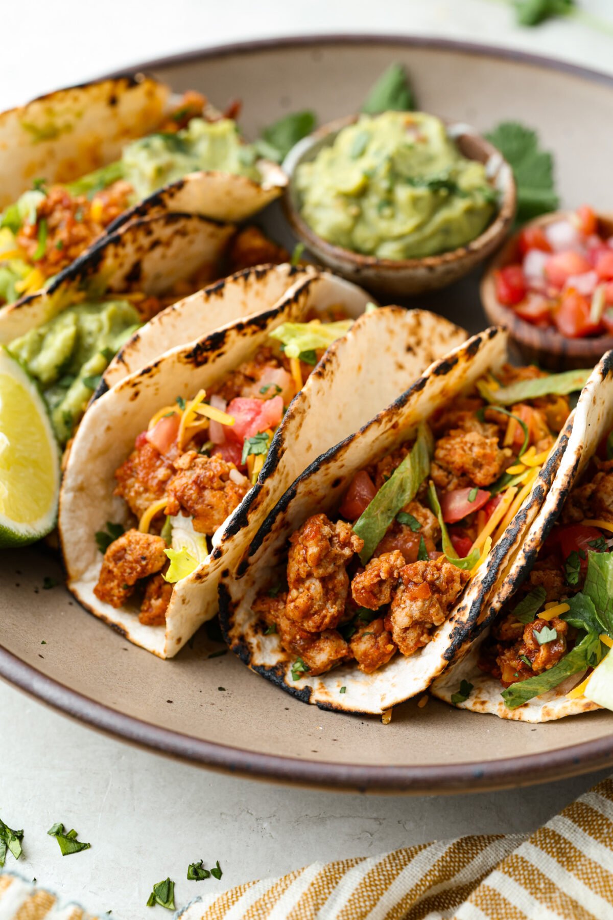 Angle shot of ground turkey tacos on a serving plate. 