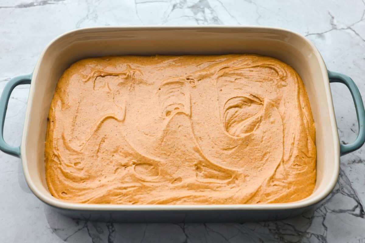 Tomato soup cake batter spread out in a baking dish. 