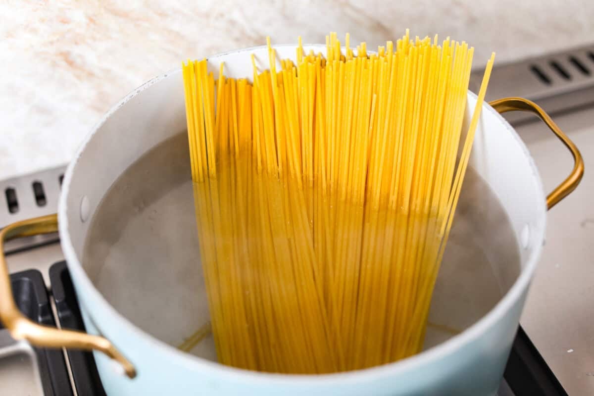 Spaghetti noodles in a pot of boiling water. 