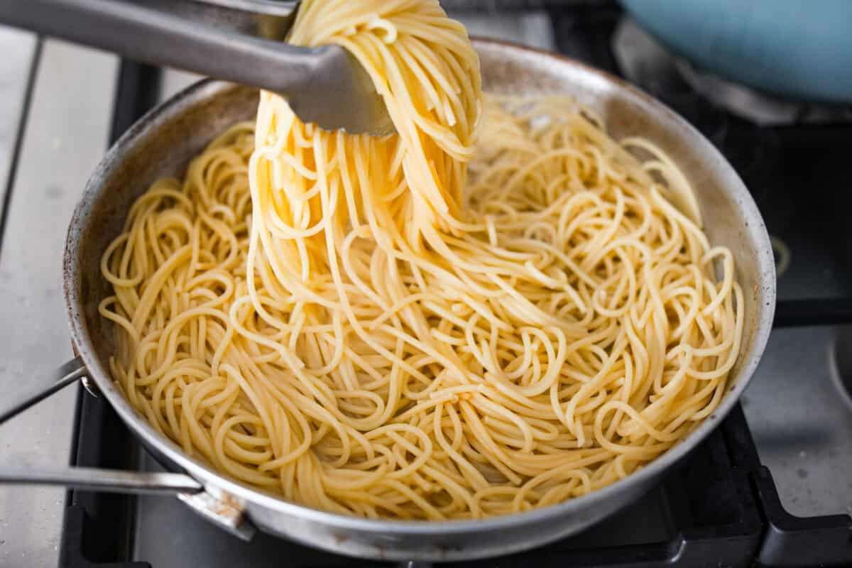 Someone tossing the noodles in the rendered fat. 