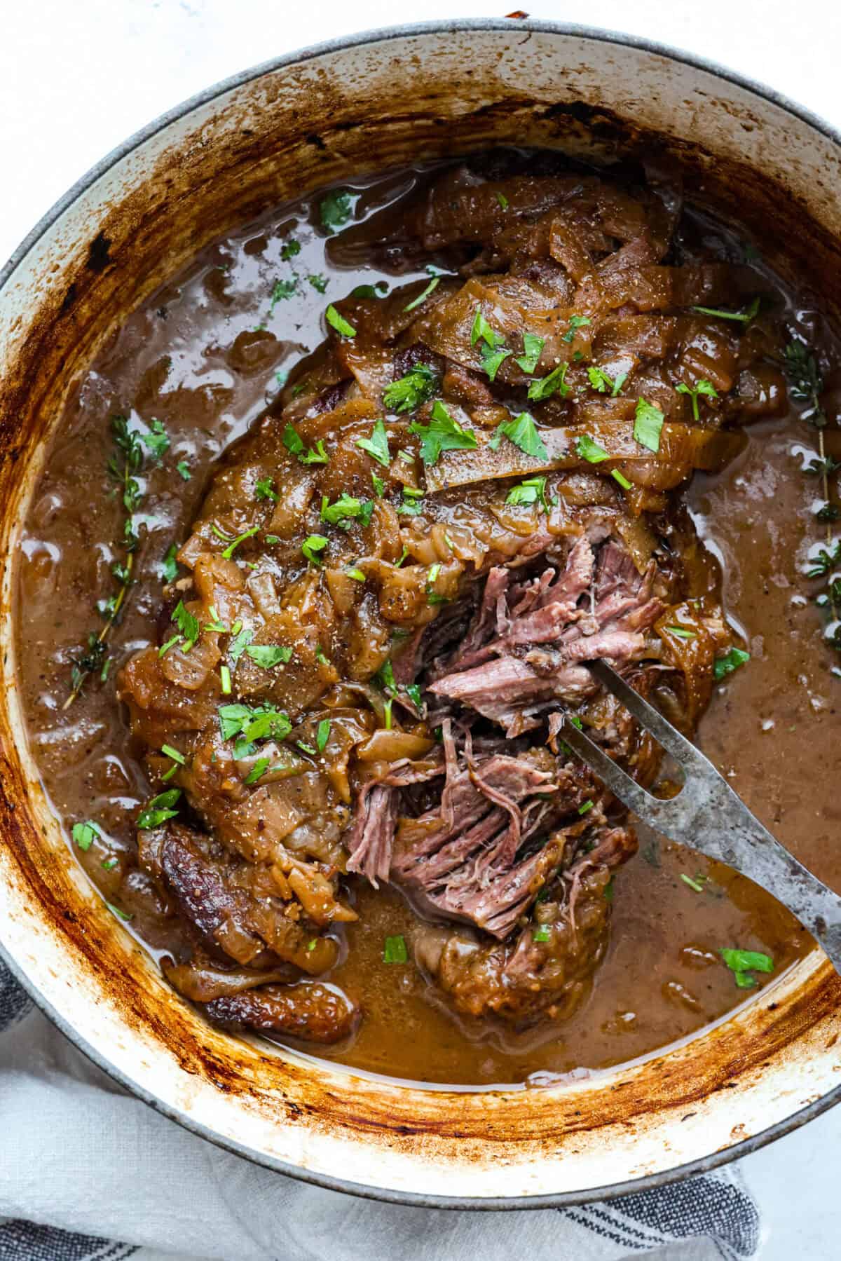 Overhead shot of cooked French onion pot roast in the dutch oven. 