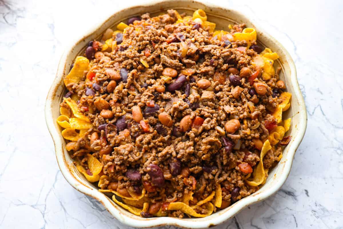 Chili layered on top of the Fritos in the pie pan.