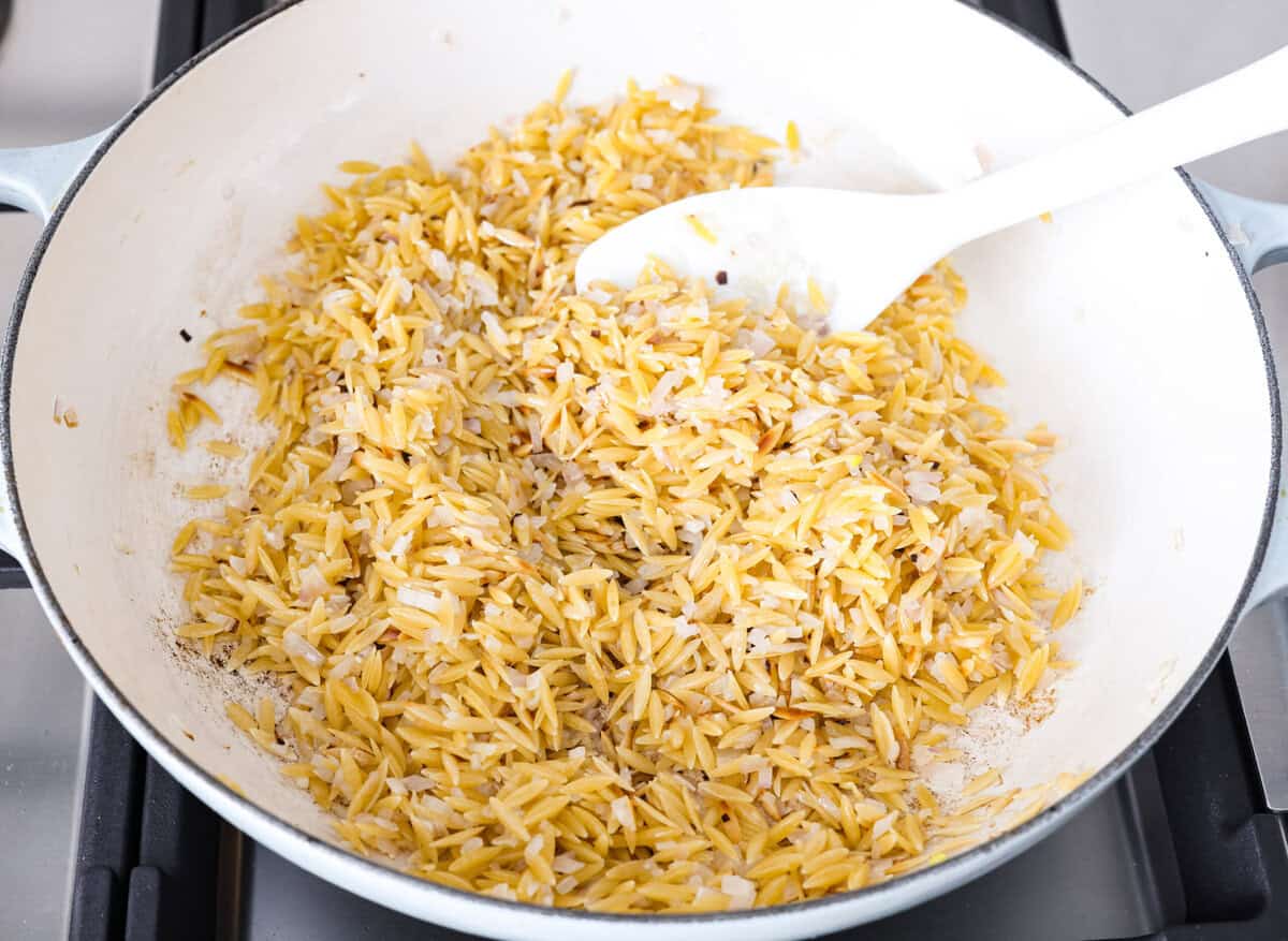 Fresh lemons make me so happy! They’re bright, cheerful, and lift me out of the winter rut. Add that citrusy sunshine to a creamy pasta, and you get this dreamy Creamy Lemon Orzo! Simple, rich, and bursting with feel-good flavor. Orzo and other ingredients all cooking together in a skillet.