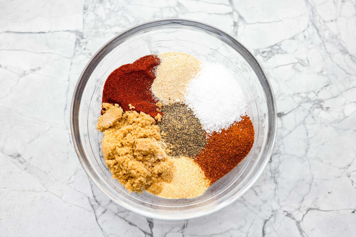 My homemade BBQ seasoning brings bold, smoky flavor to just about anything! It’s the perfect blend of sweet, savory, and just a little kick, ready to shake onto chicken, veggies, ribs, and more. Overhead shot of all of the ingredients in piles in a bowl.