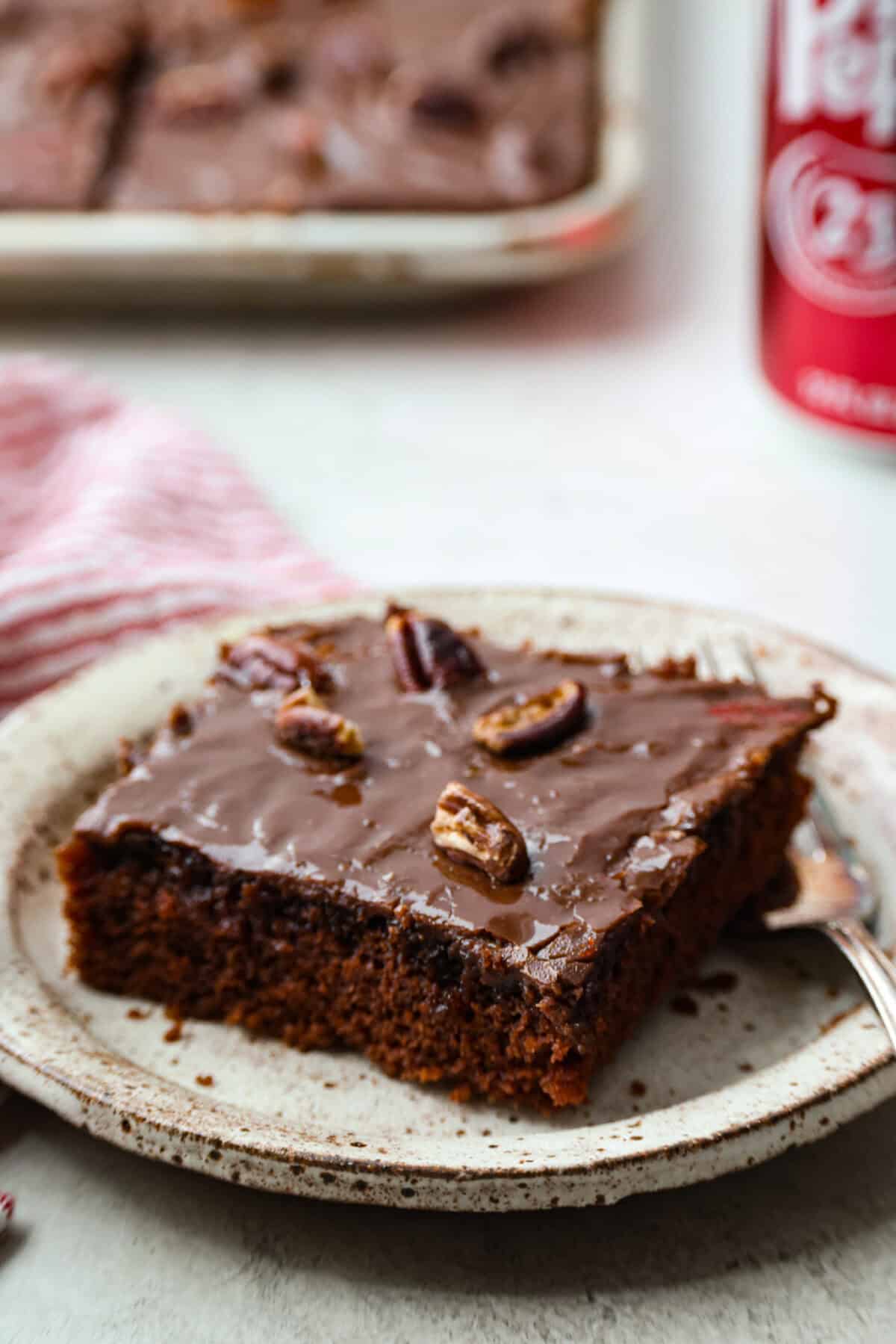Dr. Pepper Texas Sheet Cake is what happens when your favorite fizzy drink meets rich, fudgy chocolate cake, and it’s magic! The Dr. Pepper deepens the sweetness and gives the cake this warm, almost cherry-fudge vibe that’s totally irresistible. Angle shot of a slice of Dr. Pepper Sheet cake