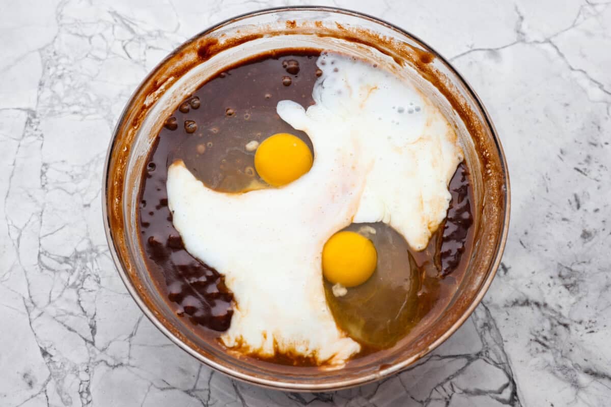 Dr. Pepper Texas Sheet Cake is what happens when your favorite fizzy drink meets rich, fudgy chocolate cake, and it’s magic! The Dr. Pepper deepens the sweetness and gives the cake this warm, almost cherry-fudge vibe that’s totally irresistible. Eggs and buttermilk added to cake batter in a bowl.