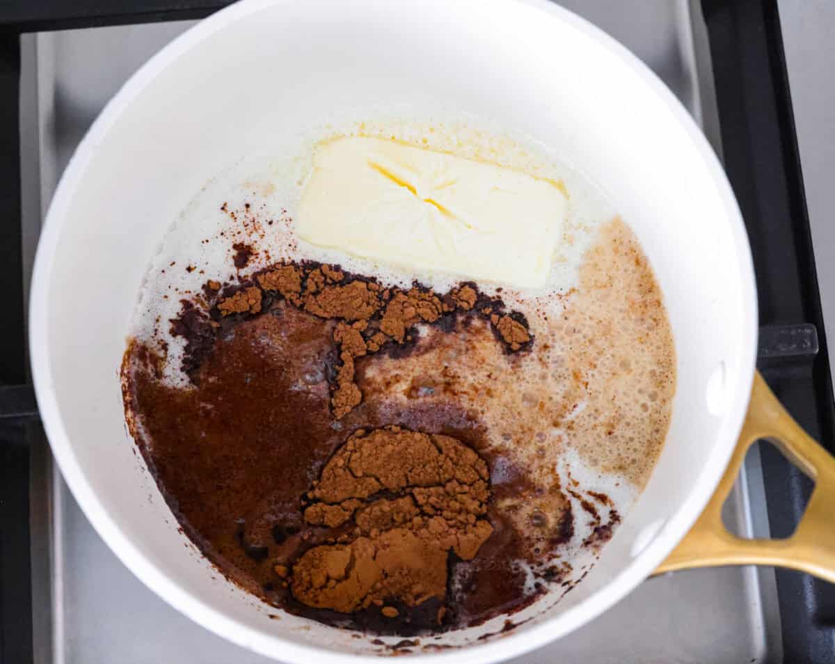 Dr. Pepper Texas Sheet Cake is what happens when your favorite fizzy drink meets rich, fudgy chocolate cake, and it’s magic! The Dr. Pepper deepens the sweetness and gives the cake this warm, almost cherry-fudge vibe that’s totally irresistible. Butter, Dr. pepper, milk, and cocoa powder melting in a saucepan.