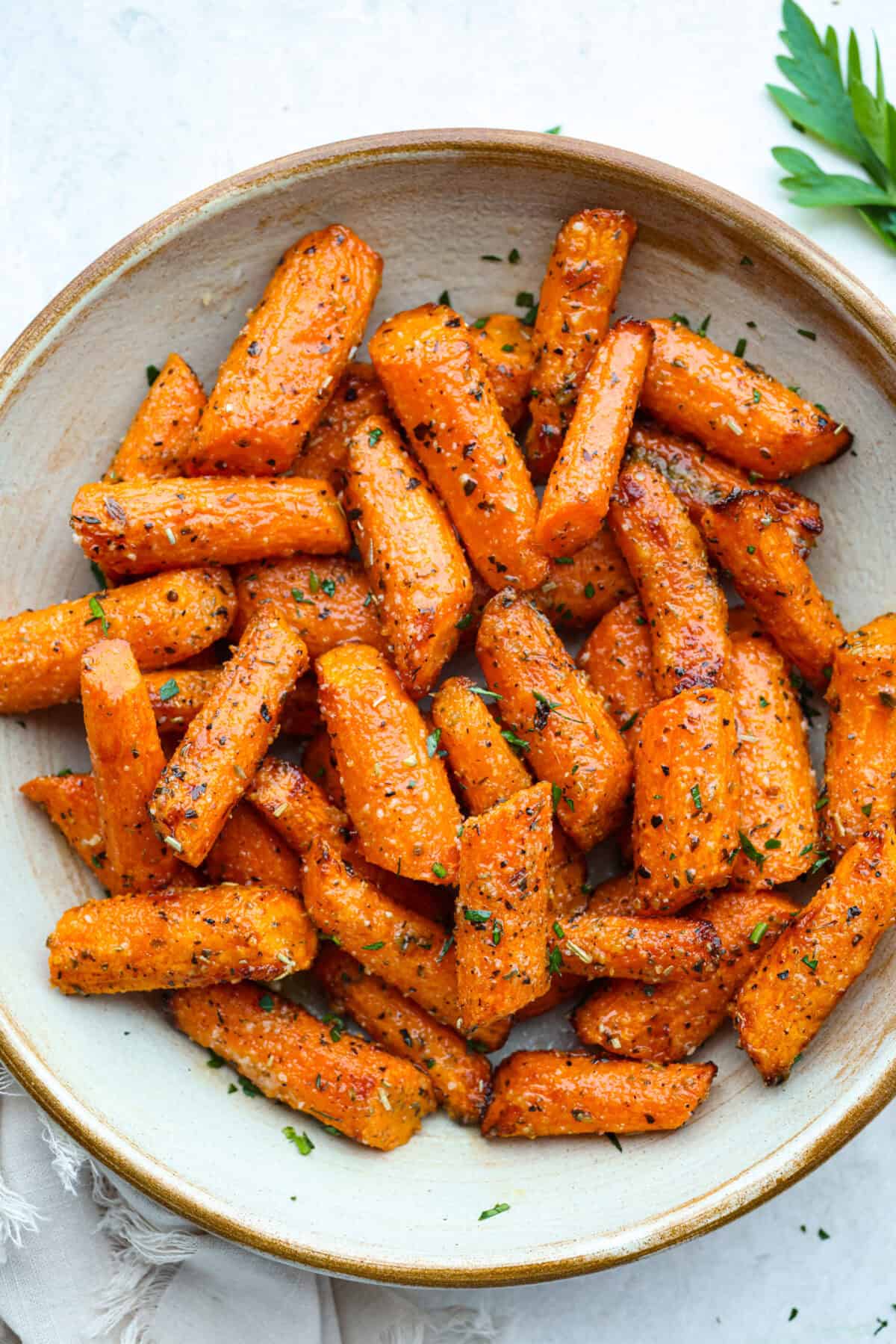 If thereโs one side dish that never sticks around for long at my house, itโs these air fryer carrots! Theyโre crisp on the outside, tender inside, and seasoned to bring out all their natural sweetnessโeven the picky eaters love them! A plate of cooked garlic carrots.