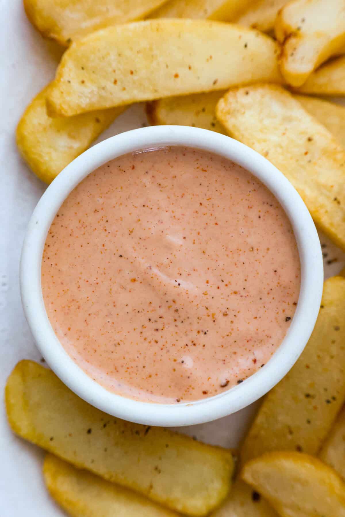 Born and raised in Utahโthe true home of fry sauceโIโve perfected this recipe to pair with just about everything. This isnโt your average ketchup-mayo mix. The secret ingredient? Pickle Brine. Stay with me! It brings the BEST tang to the sauce!! Overhead shot of a small bowl of fry sauce surrounded by french fries.