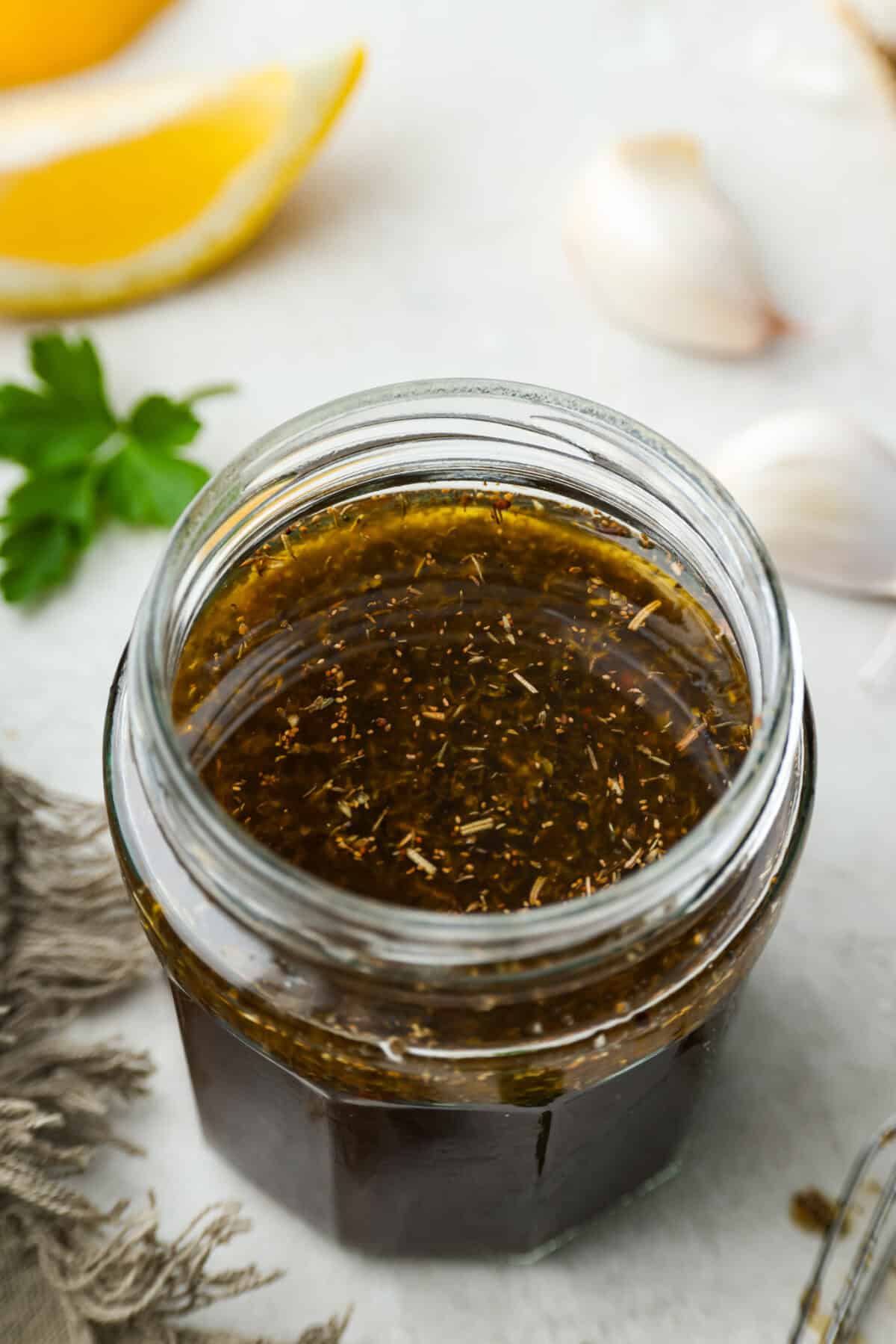Angle shot of a glass jar with steak marinade inside. 