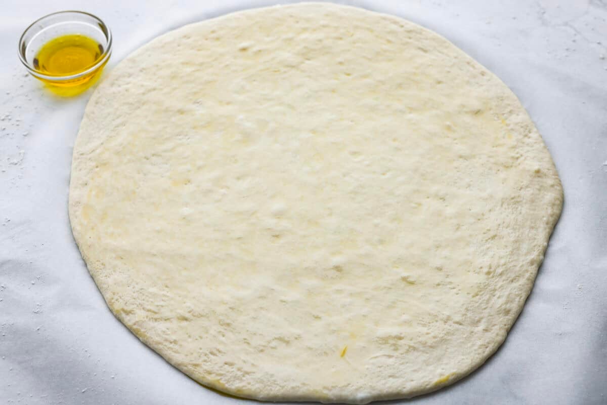 I’m all about pizza and grilling, so when I can combine the two, it’s a win. The grill gives pizza that smoky, crispy flavor you can’t get from the oven. Trust me, this grilled pizza will have you hooked! Pizza dough rolled out into a circle.