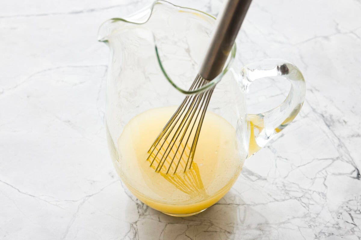 If you love iced tea, you’re going to be obsessed with this Arnold Palmer. The combo of crisp black tea and tangy lemonade is pure summer magic. It’s simple, refreshing, and always just what you need. Someone stilling lemon juice and sugar in a large pitcher.