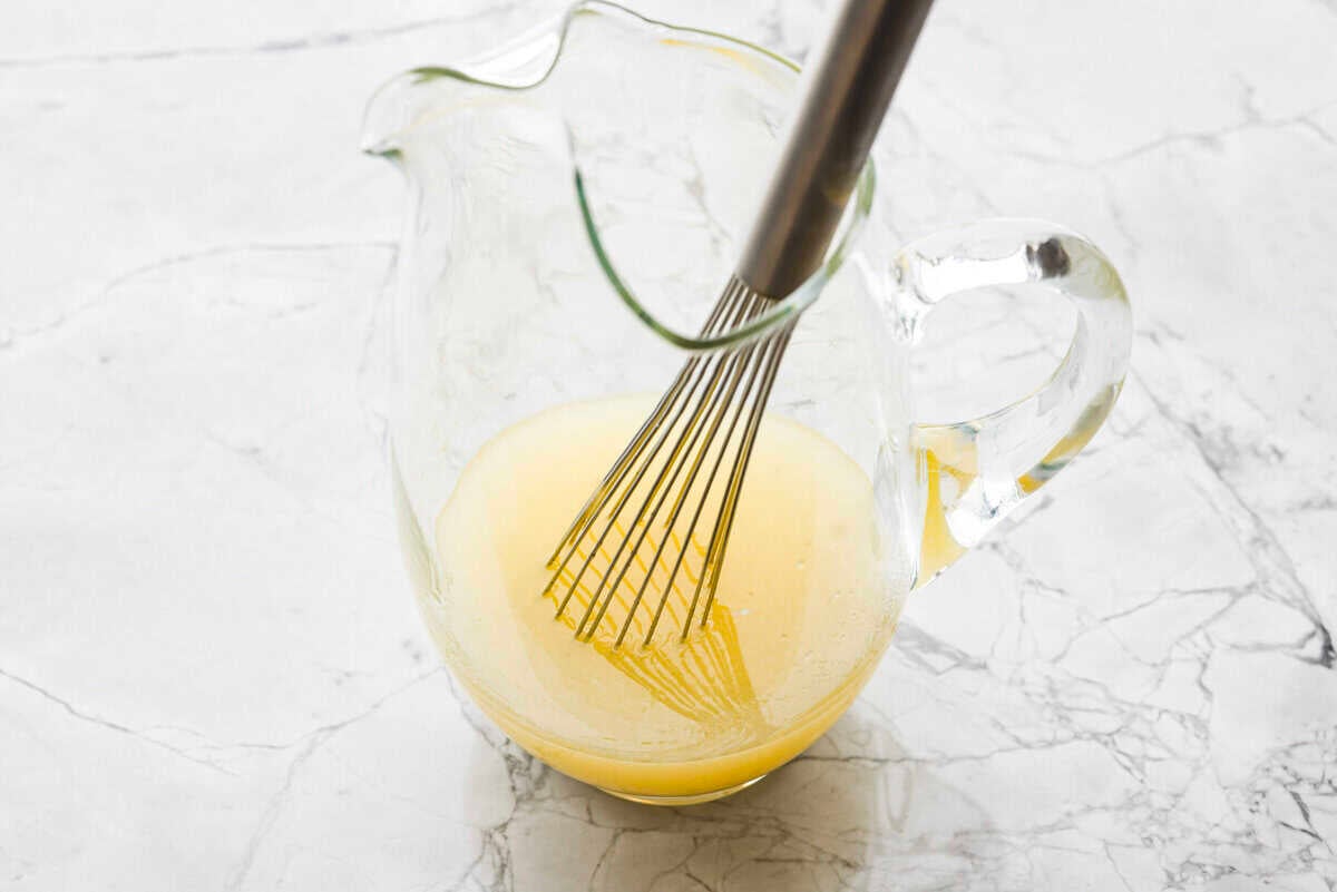 If you love iced tea, you’re going to be obsessed with this Arnold Palmer. The combo of crisp black tea and tangy lemonade is pure summer magic. It’s simple, refreshing, and always just what you need. Someone stilling lemon juice and sugar in a large pitcher.