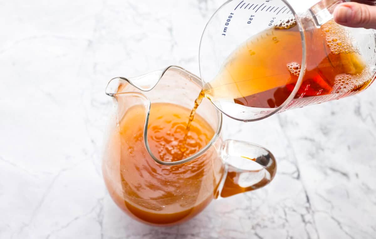 If you love iced tea, you’re going to be obsessed with this Arnold Palmer. The combo of crisp black tea and tangy lemonade is pure summer magic. It’s simple, refreshing, and always just what you need. Someone pouring unsweetened black tea into the pitcher with lemon juice and sugar.