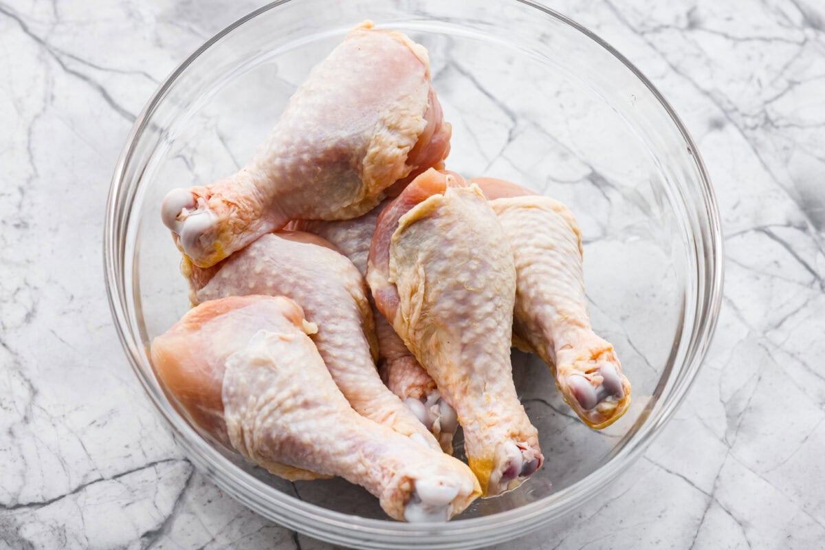 Raw chicken legs in a bowl. 