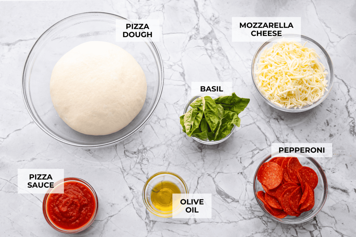 I’m all about pizza and grilling, so when I can combine the two, it’s a win. The grill gives pizza that smoky, crispy flavor you can’t get from the oven. Trust me, this grilled pizza will have you hooked! Overhead shot of labeled ingredients.