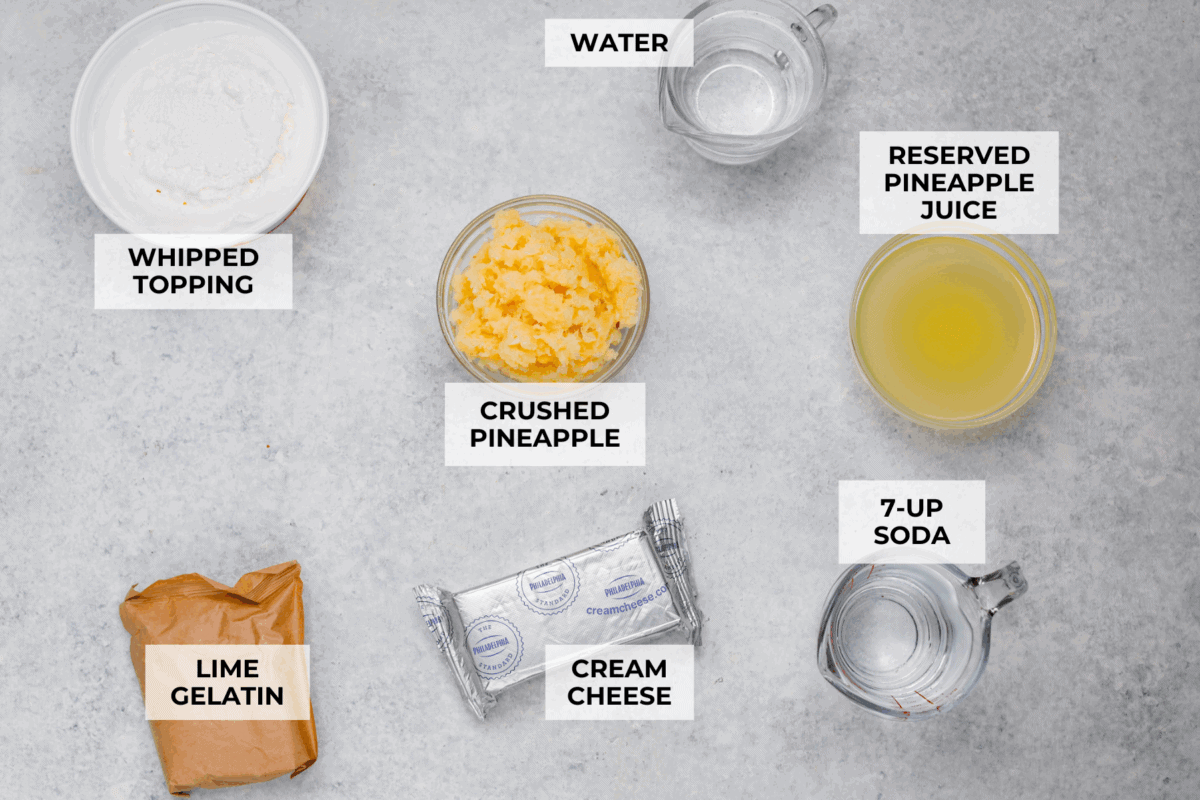 I gave the vintage lime Jello salad a modern makeover. With cream cheese for tang, pineapple and lime for zip, and a splash of 7-Up for that light, fizzy fluff, this retro-inspired treat is now a sweet, citrusy dream I know you guys will love! Overhead shot of labeled ingredients.