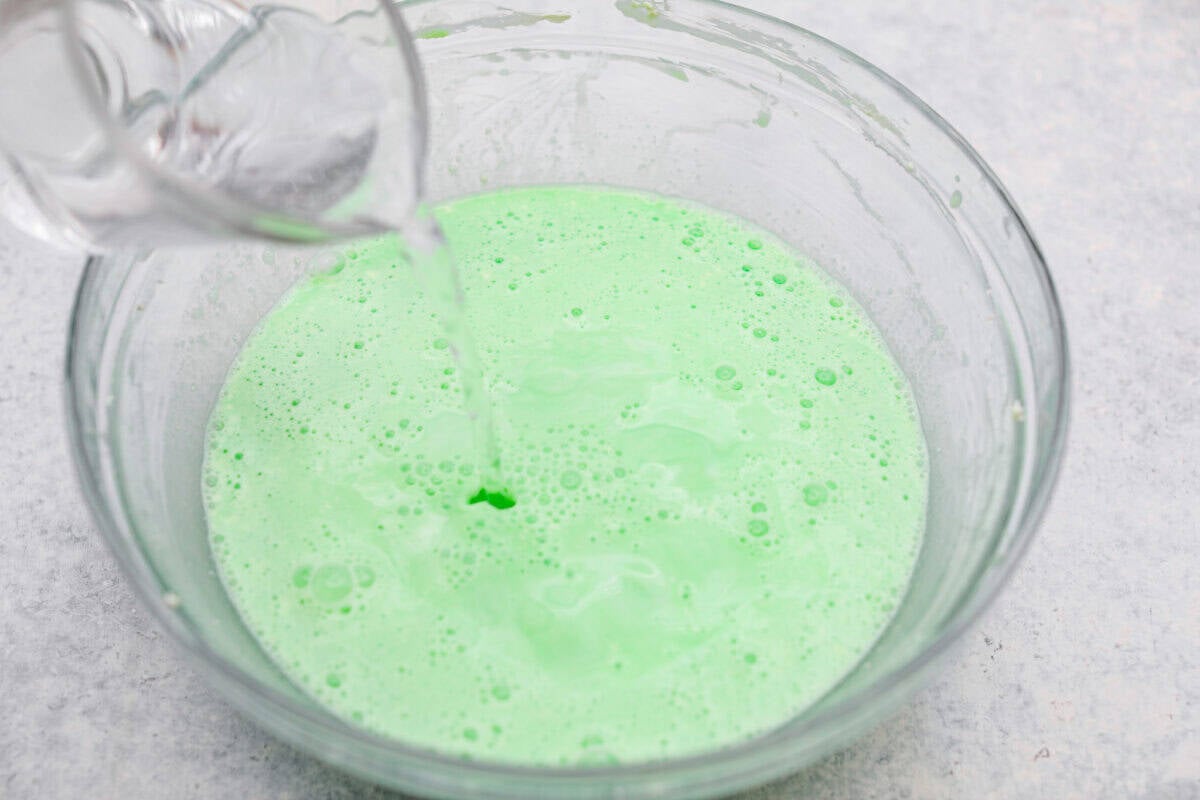 I gave the vintage lime Jello salad a modern makeover. With cream cheese for tang, pineapple and lime for zip, and a splash of 7-Up for that light, fizzy fluff, this retro-inspired treat is now a sweet, citrusy dream I know you guys will love! Someone pouring 7Up into the cream cheese mixture.