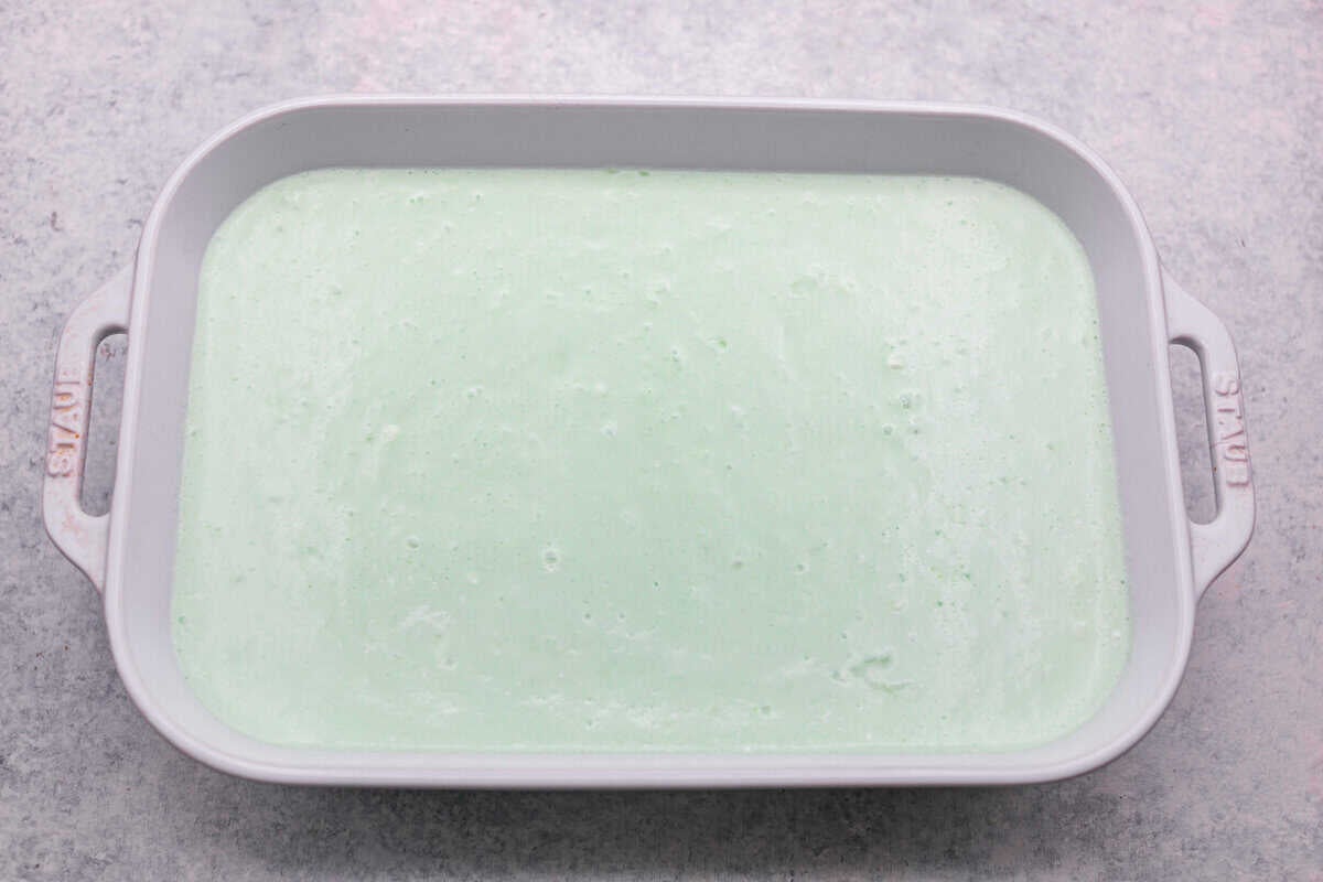 I gave the vintage lime Jello salad a modern makeover. With cream cheese for tang, pineapple and lime for zip, and a splash of 7-Up for that light, fizzy fluff, this retro-inspired treat is now a sweet, citrusy dream I know you guys will love! All of the lime jello salad ingredients mixed together and added to the prepared baking dish.