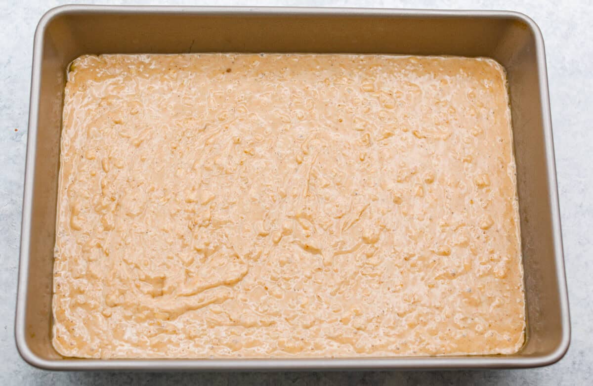 Oatmeal cake batter in the bottom of the pan. 