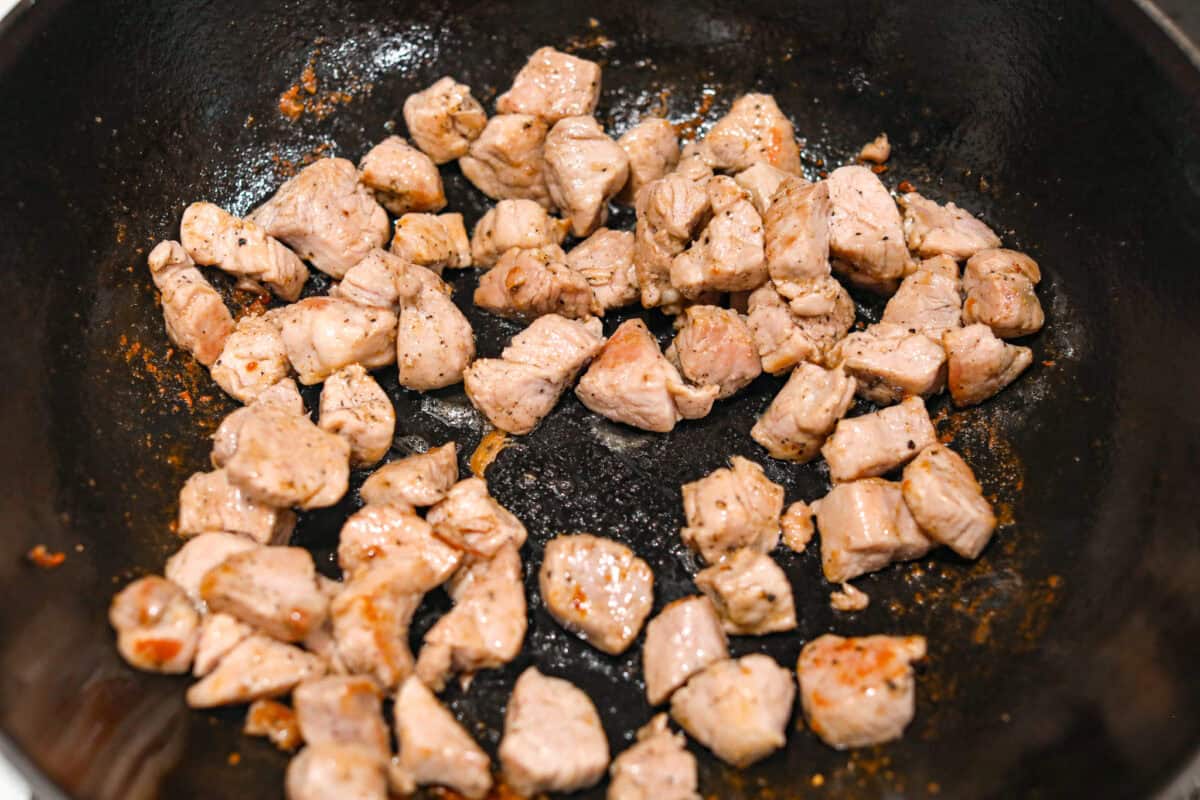 Pork cooking in a skillet. 