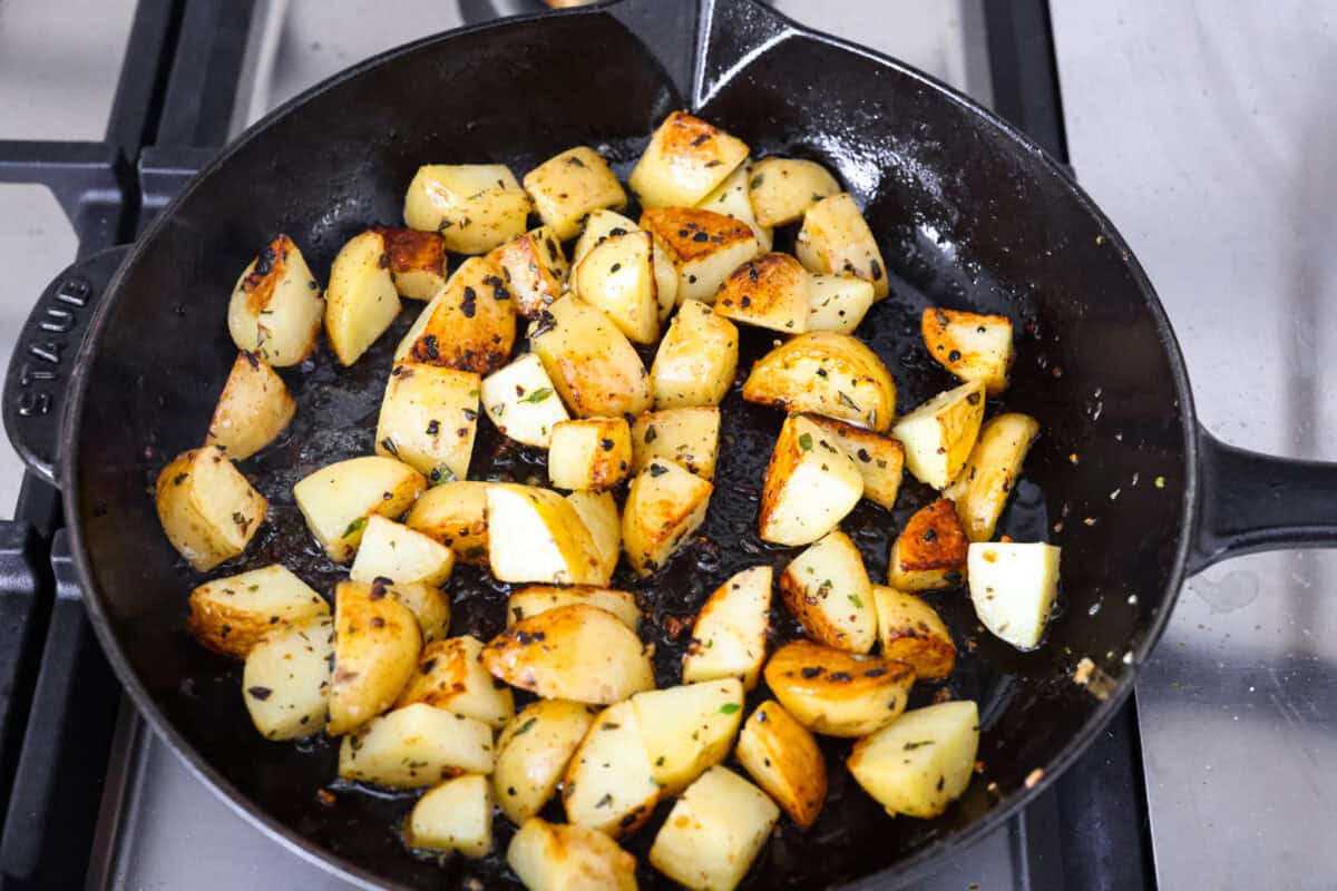 Potatoes cooking in a skillet. 