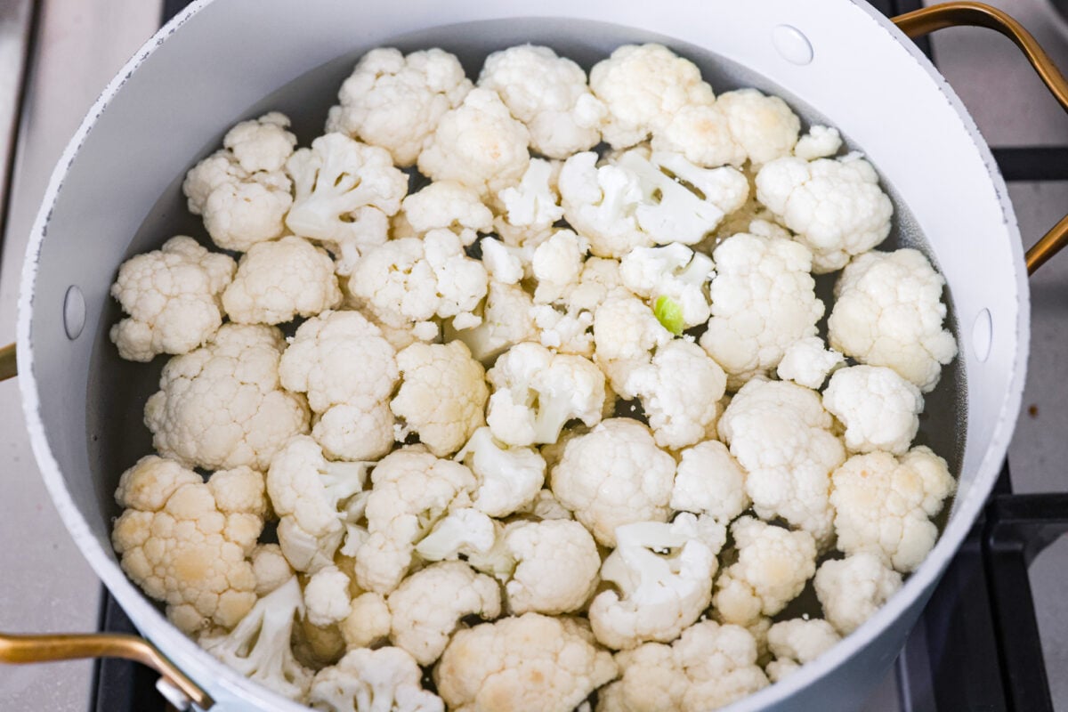 These crispy cauliflower fritters are how I trick my kids into eating veggies. They even ask for seconds. The parmesan and savory seasonings make these golden, cheesy, and packed with flavor! Cauliflower florets in a pot of water.