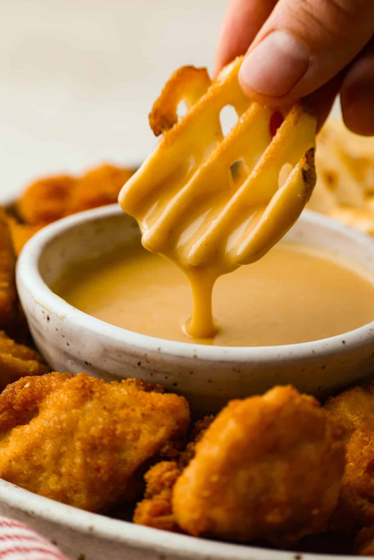My boys were blowing through bottles of this stuff weekly. Between the price and the junk in it, I said nope and made my own Chick-fil-A Sauce. Itโs smoky, sweet, tangy, creamy magic... and honestly? Way better than the bottle. Someone dipping a fry in homemade Chick-fil-A sauce.