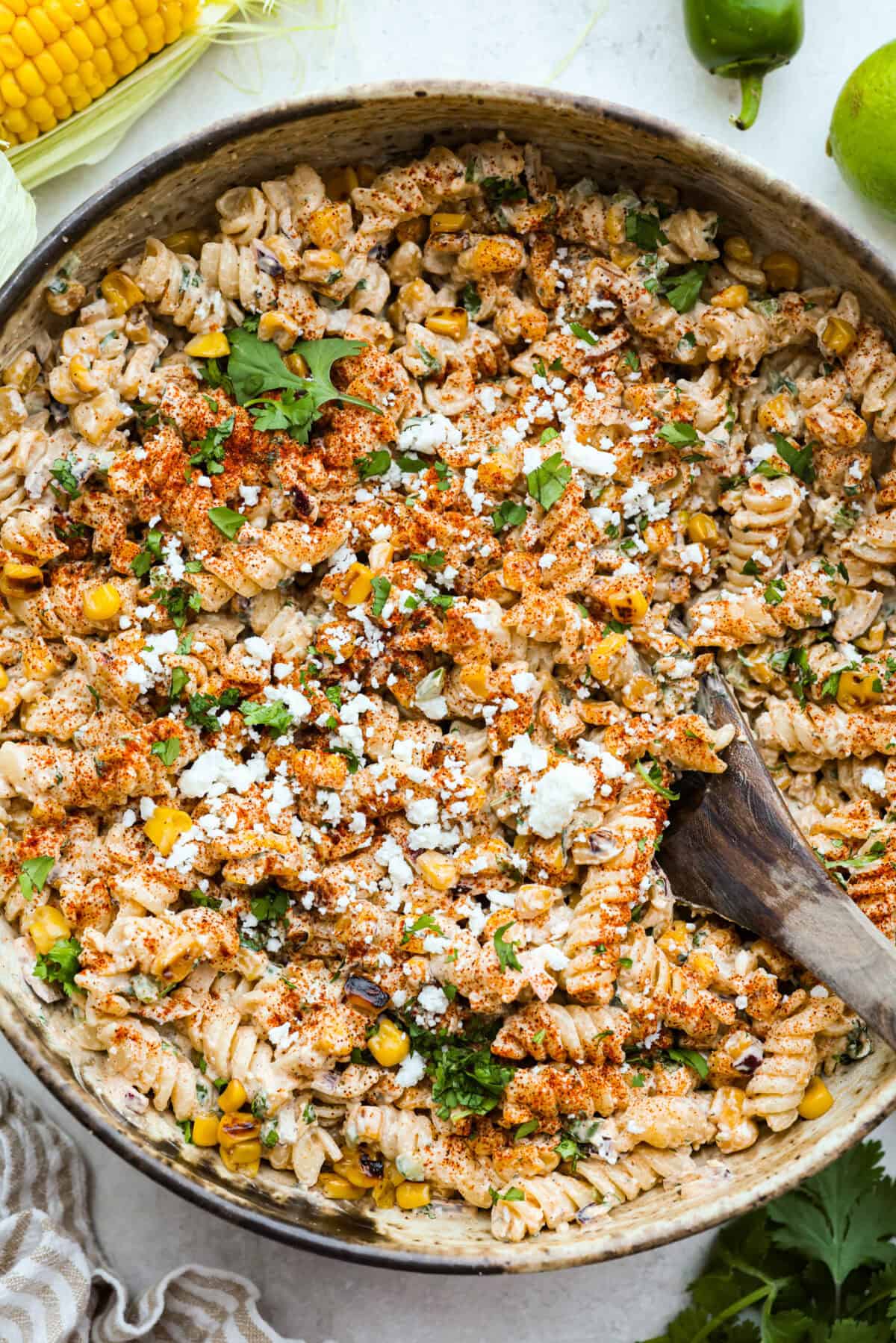 Guys, I’m obsessed with elote, so obviously I had to turn all that smoky, creamy, cheesy, limey magic into a pasta salad big enough to feed a crowd. This one’s guaranteed to disappear fast! Overhead shot of elote pasta salad in a serving bowl.