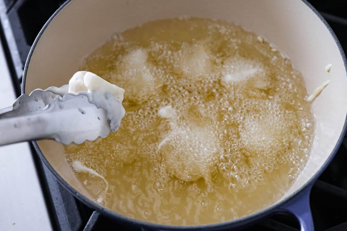 Frying dipped cauliflower in oil. 