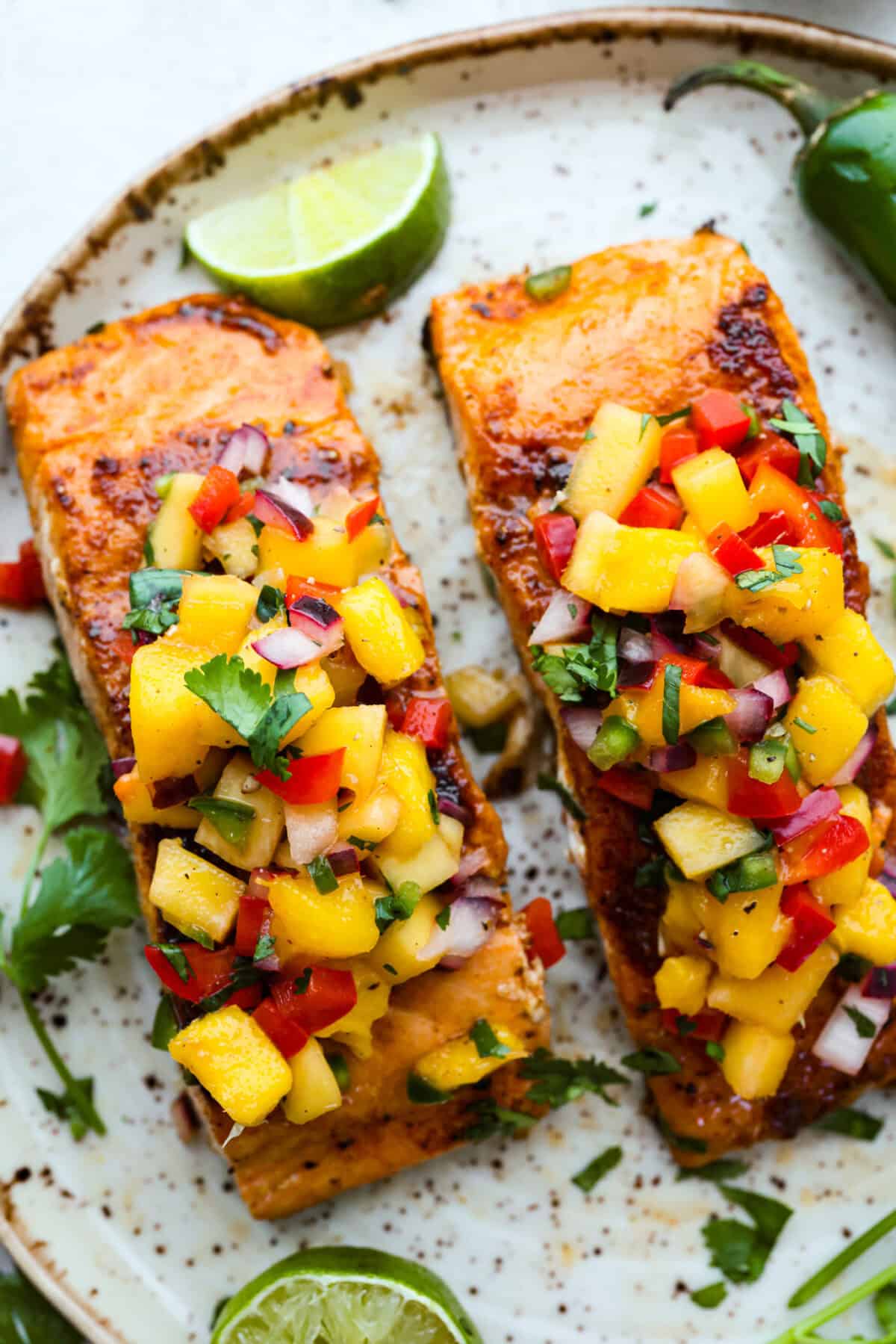 Iโm obsessed with salmon, and this Mango Salsa Salmon might just be my new favorite! Itโs super flavorful, fast to cook, and somehow my kids donโt fight me on it. That bright, juicy salsa on top? Freaking amazing. I could eat it every night! Overhead shot of mango salsa salmon on a plate.