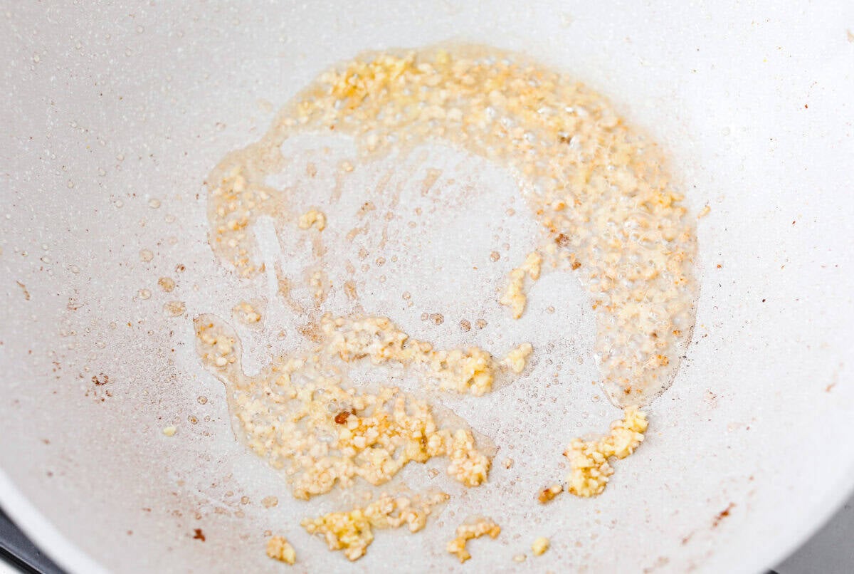 Garlic and oil cooking in a skillet. 