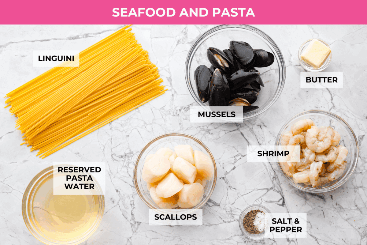 My seafood pasta has a silky lemon garlic cream sauce that is to die for! It's loaded with tender shrimp, scallops, and mussels. It’s the perfect date night dish! Overhead shot of labeled. seafood pasta ingredients.
