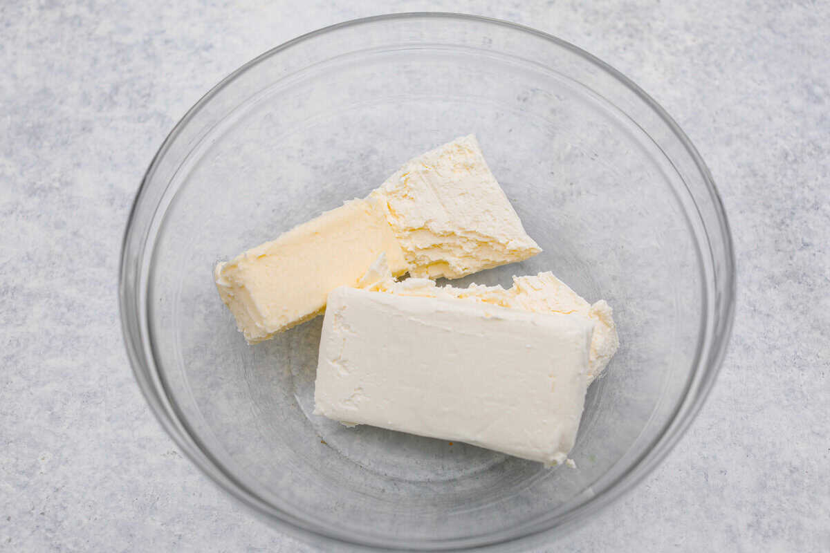 Craving a bright and sunny dessert? This pineapple delight will hit the spot! With a buttery crust, creamy filling, and sweet pineapple topping, it’s light, tropical, and totally irresistible! Cream cheese and butter added to a bowl.