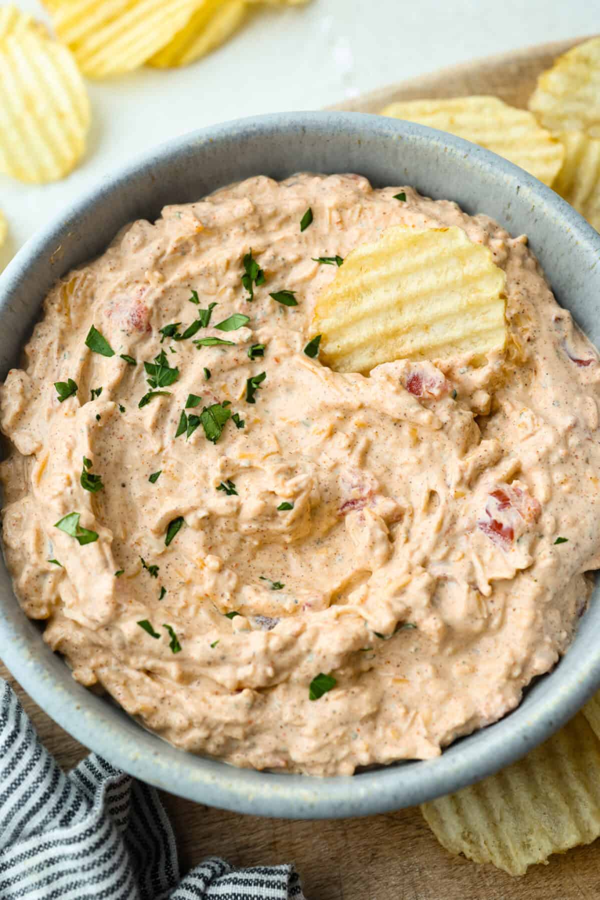 This viral boat dip is blowing up on the socials, and for good reason. It's creamy, cheesy, and the best flavor. It's the easiest appetizer for lake days, BBQs, or any summer hangout. Boat dip in a serving bowl with a potato chip.