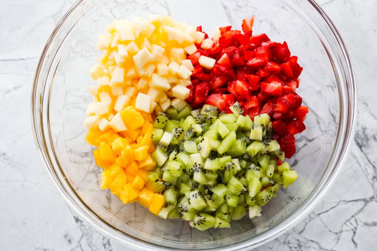 Diced fruit added to a bowl. 