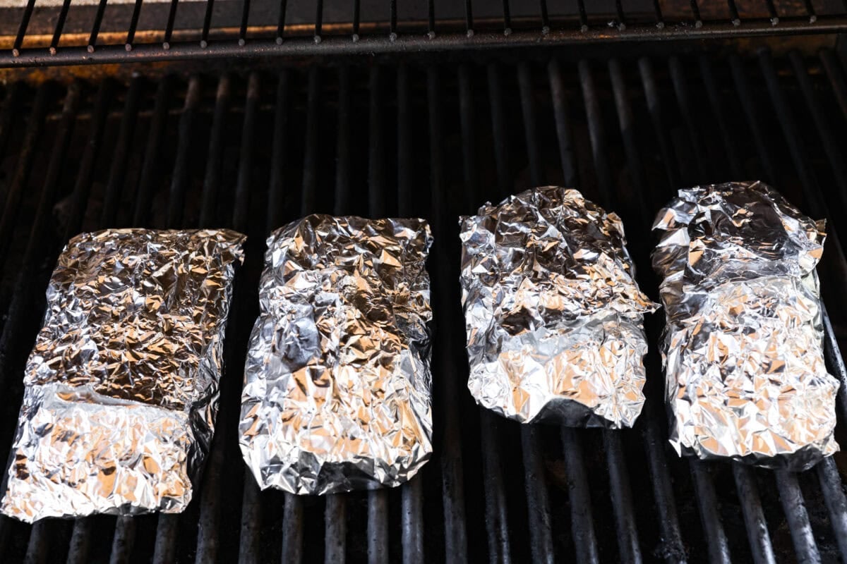 These meatball foil packets have juicy meatballs, sweet pineapple, colorful veggies, covered in sticky teriyaki sauce, and grilled to perfection. Easy to make, fun to eat, and no dishes to wash! Yes, please! Foil Packets placed on the grill.