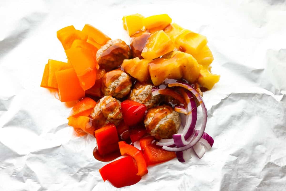 These meatball foil packets have juicy meatballs, sweet pineapple, colorful veggies, covered in sticky teriyaki sauce, and grilled to perfection. Easy to make, fun to eat, and no dishes to wash! Yes, please! Teriyaki sauce drizzled over the meat and veggies.