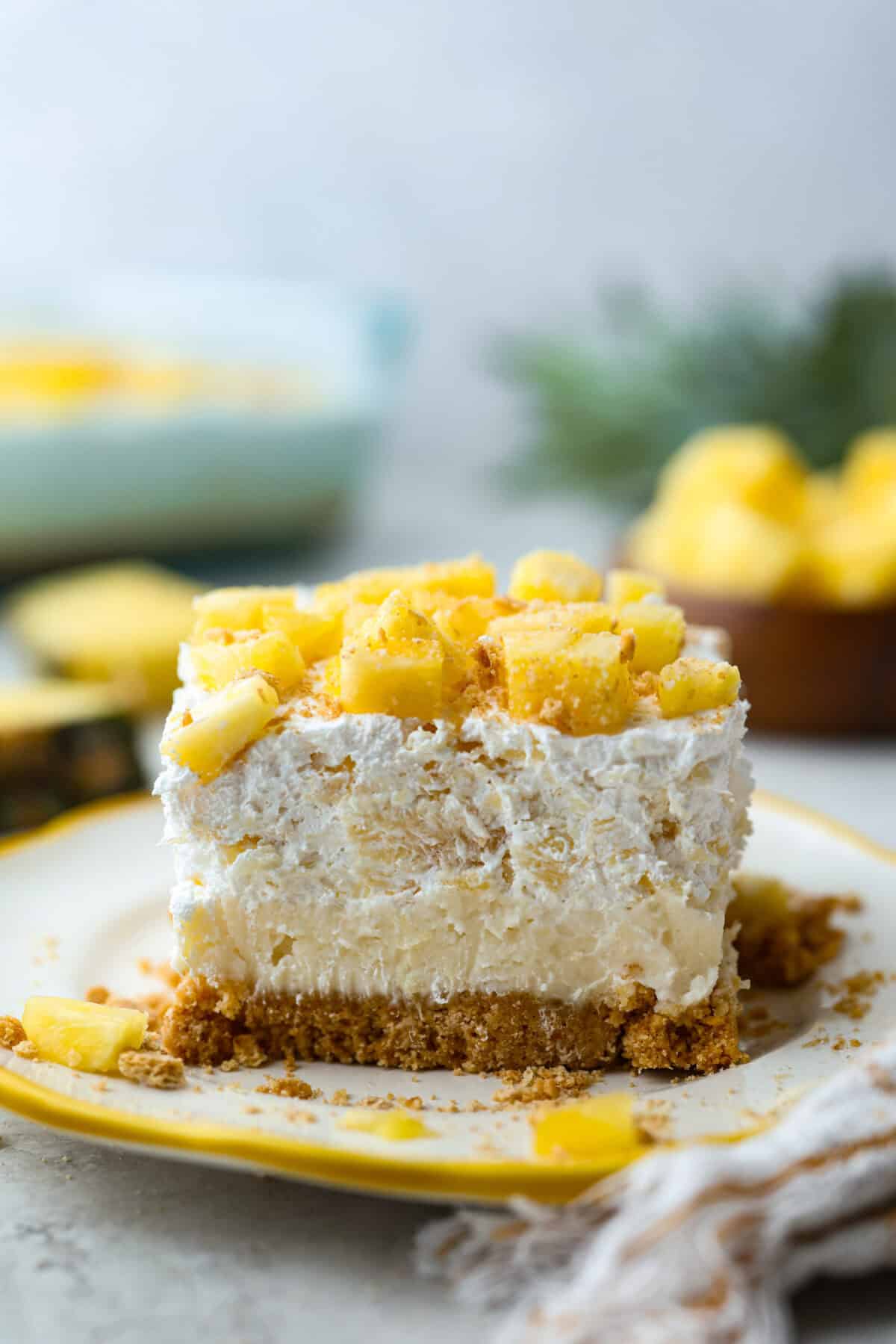 Side shot of a slice of pineapple delight layered dessert. 