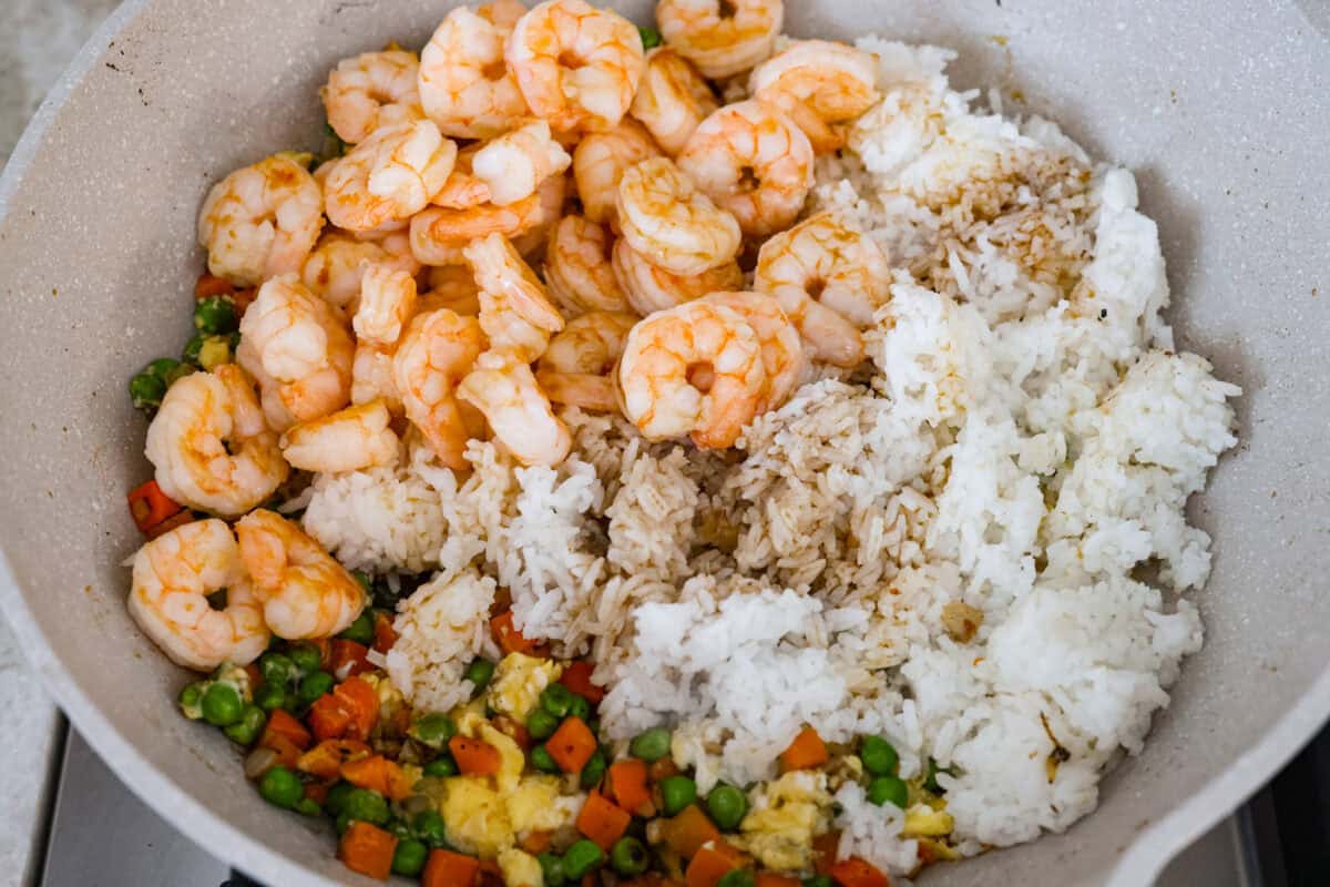 Rice, shrimp, sauce, and seasonings added to the skillet with the veggies and shrimp.