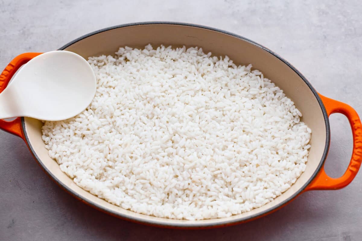 Cooked and seasoned rice pressed into the bottom of a baking dish.