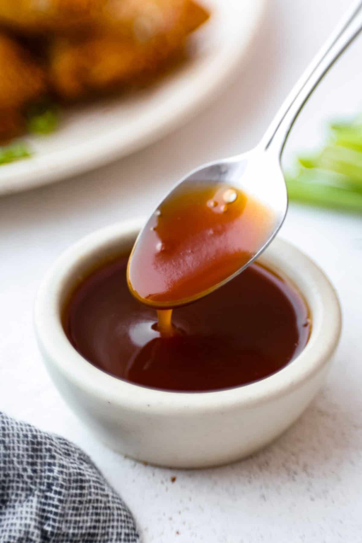 I’ve tested a lot of sweet and sour sauces, and this is the one I always come back to. My recipe uses pineapple juice for that perfect tangy-sweet balance, and it’s ready in minutes with pantry staples. Someone dipping a spoon in sweet and sour sauce.