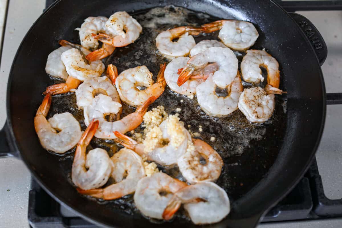 Shrimp and garlic added to the hot skillet.